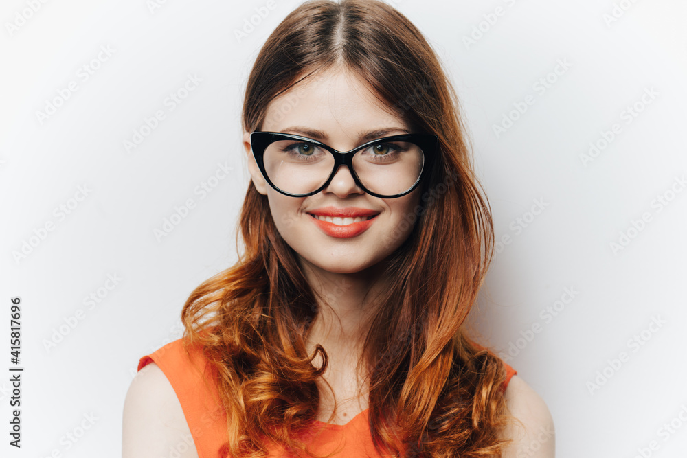 Business woman in orange shirt with notepad in hands fashion glasses Business woman in orange shirt with notepad in hands fashion glasses