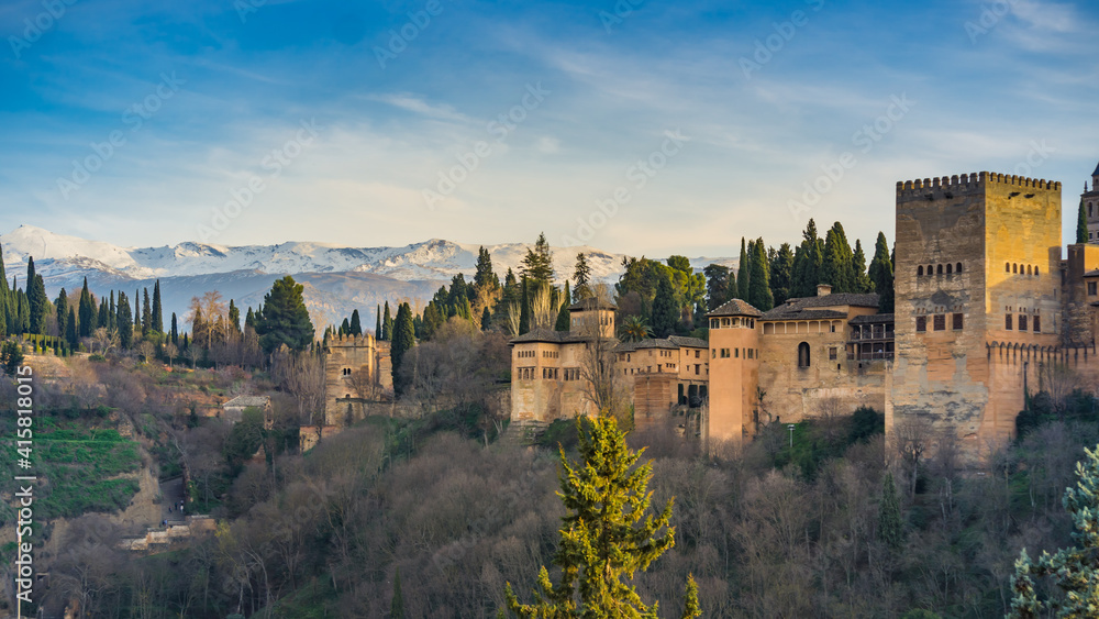 View at sunset on the Alcazaba, the medieval fortress part of the Alhambra complex in Granada, Andalusia, Spain, with the Sierra Nevada mountains in the background