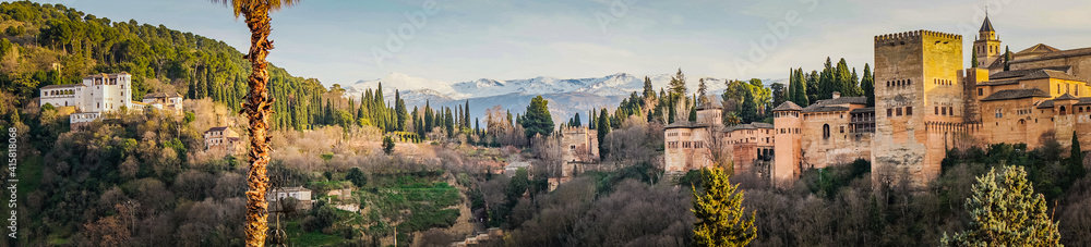 Panorama on the Alhambra complex (Generalife palace and Alcazaba fortifications) and the snow capped Sierra Nevada mountains from the Albaicin district of Granada (Spain)