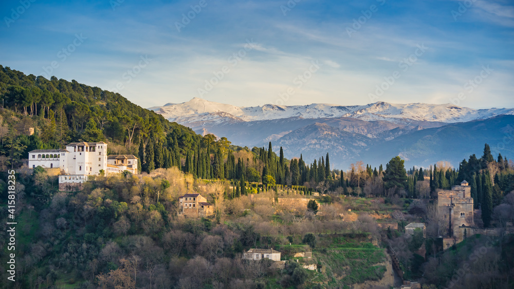 View on the Generalife palace of the Alhambra complex and the snow capped Sierra Nevada mountains from the Albaicin district of Granada (Spain)