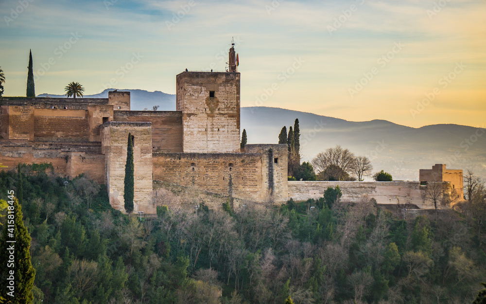 View at sunset on the Alcazaba, the medieval fortress part of the Alhambra complex in Granada, Andalusia, Spain, with the Sierra Nevada mountains in the background