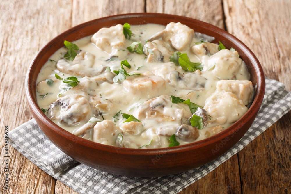 Mushrooms and Chicken in White Sauce closeup in the plate on the table. Horizontal Mushrooms and Chicken in White Sauce closeup in the plate on the table. Horizontal