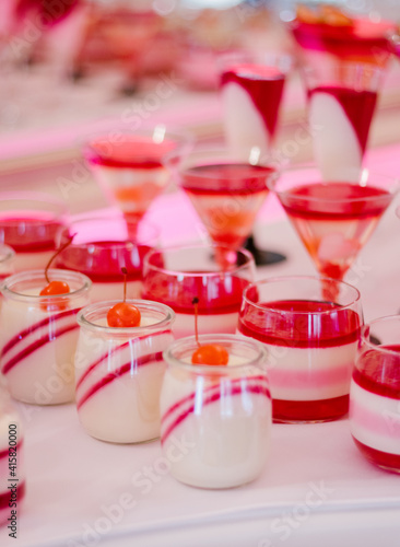 Wedding candy bar full of red and white desserts on a white table
