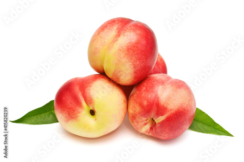 Heap of whole peaches with leaves isolated on white background