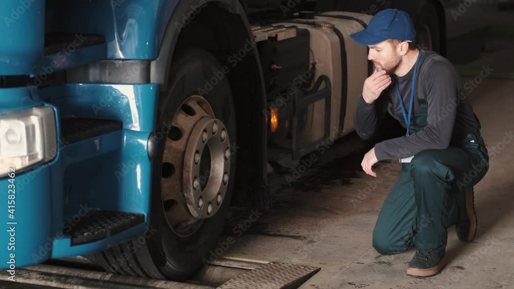 a mechanic is doing a checkup and fixing the truck for it to run a mechanic is doing a checkup and fixing the truck for it to run