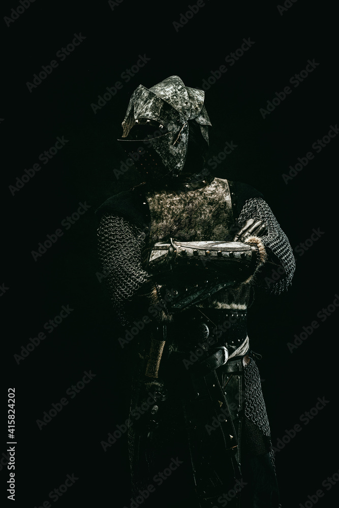 Naklejka premium Portrait of a medieval fighter in armor with his arms crossed