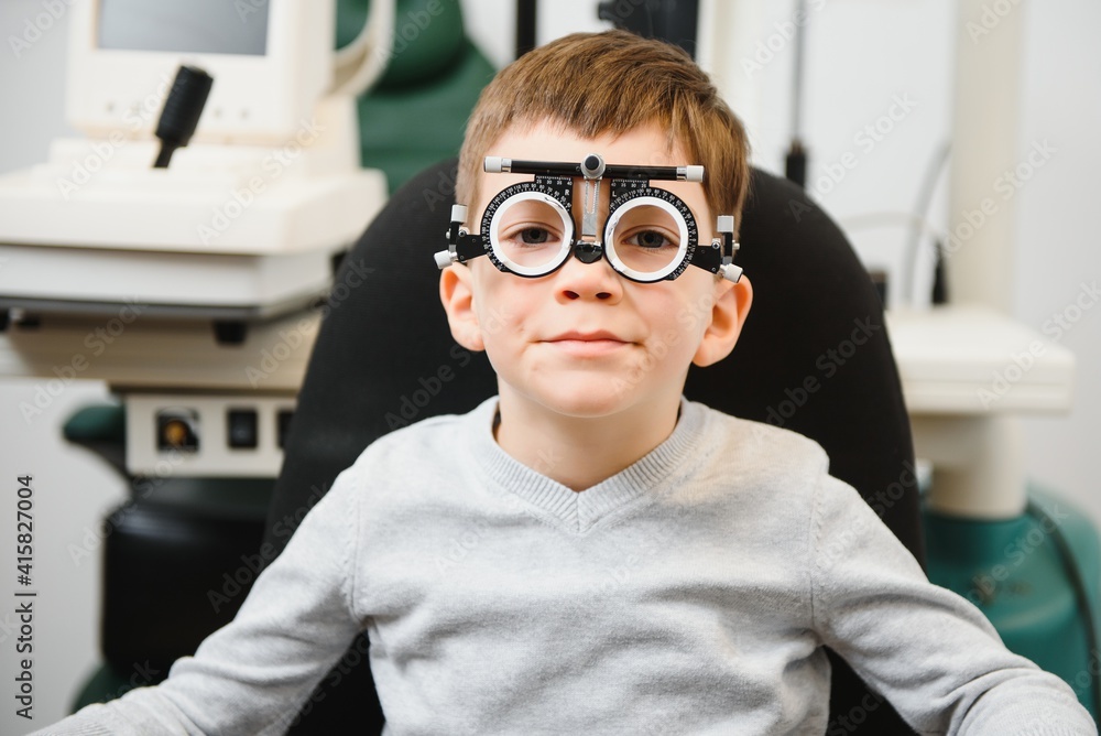 Cheerful child boy in glasses checks eye vision pediatric ophthalmologist. Cheerful child boy in glasses checks eye vision pediatric ophthalmologist.