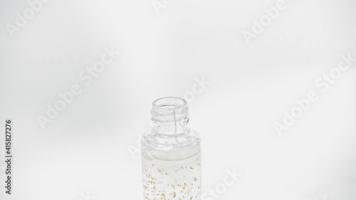 close up of glass bottle with essential oil on white