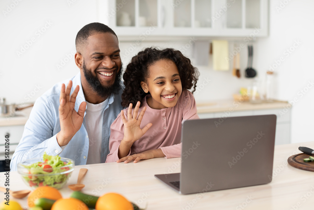 Black man and girl having videocall using laptop waving hands Black man and girl having videocall using laptop waving hands