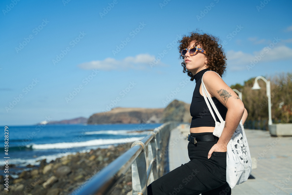 young girl with curly hair enjoying the landscape on a sunny day in the canary islands young girl with curly hair enjoying the landscape on a sunny day in the canary islands