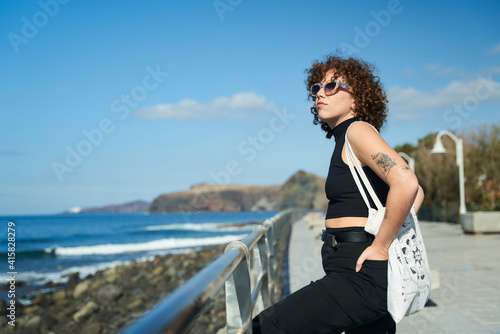 young girl with curly hair enjoying the landscape on a sunny day in the canary islands © Miguel Moebius