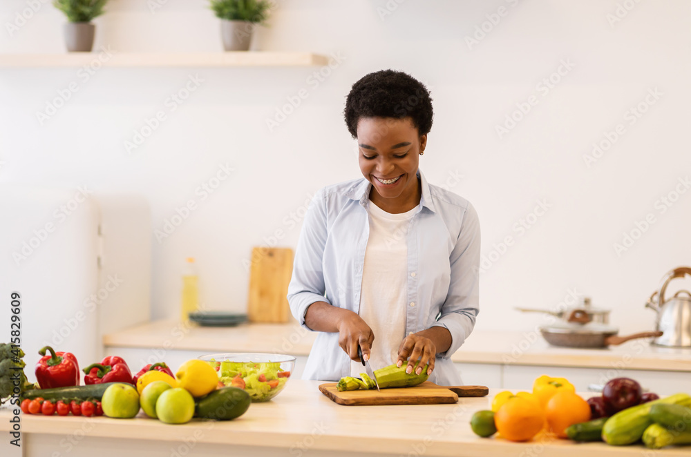 Cheerful Black Lady Cooking Preparing Dinner Standing In Kitchen Indoors