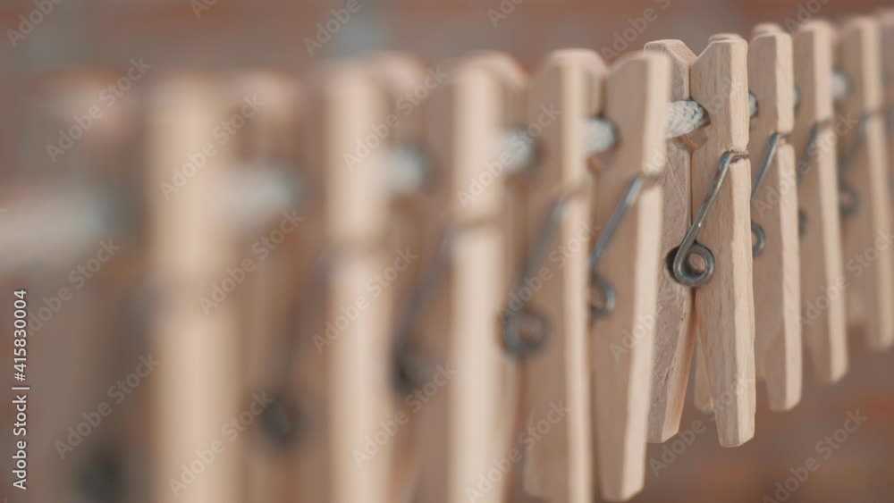 Wooden clothespins hanging on a rope. Selective focus on one clothespin Wooden clothespins hanging on a rope. Selective focus on one clothespin