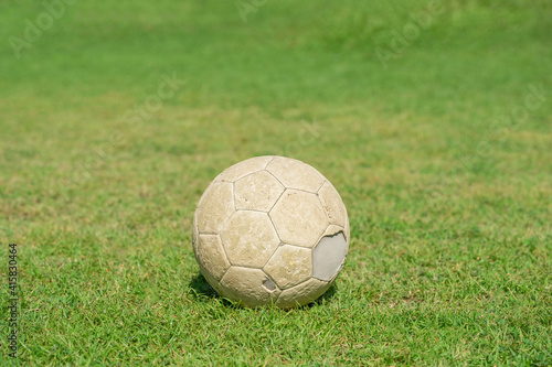 Old soccer ball on green grass of soccer field. © Lifestyle Graphic