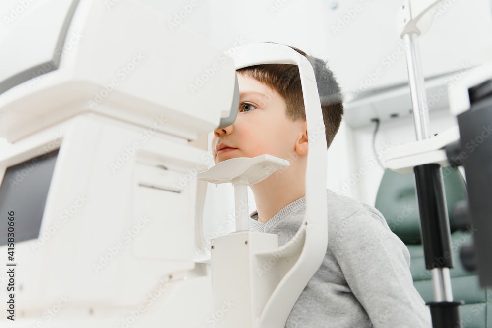 Optometry concept. Female optometrist optician doctor examines eyesight of child boy in eye ophthalmological clinic Optometry concept. Female optometrist optician doctor examines eyesight of child boy in eye ophthalmological clinic