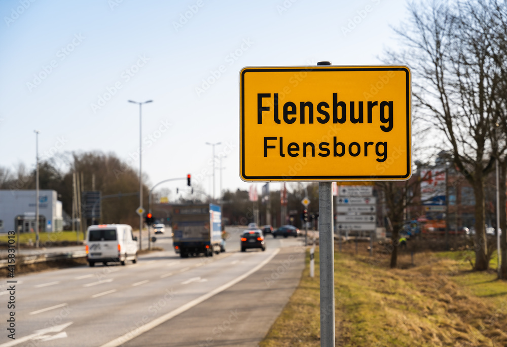 Local sign of the city of Flensburg in north Germany with traffic in background