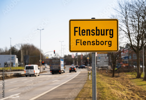Local sign of the city of Flensburg in north Germany with traffic in background © blumbaker