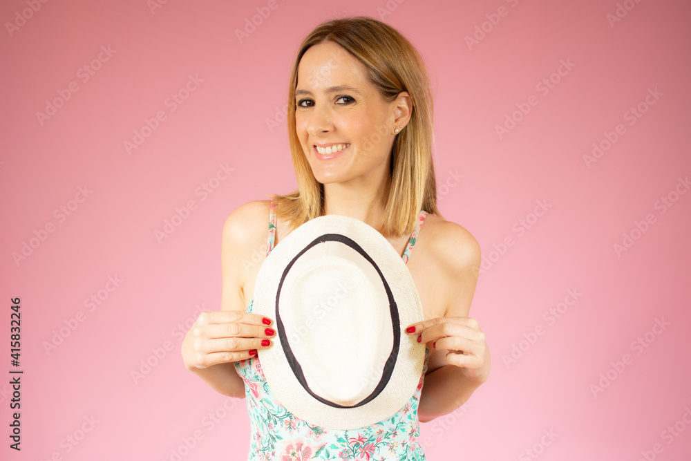 Beautiful young woman wearing bodysuit and straw hat standing isolated over pink background Beautiful young woman wearing bodysuit and straw hat standing isolated over pink background