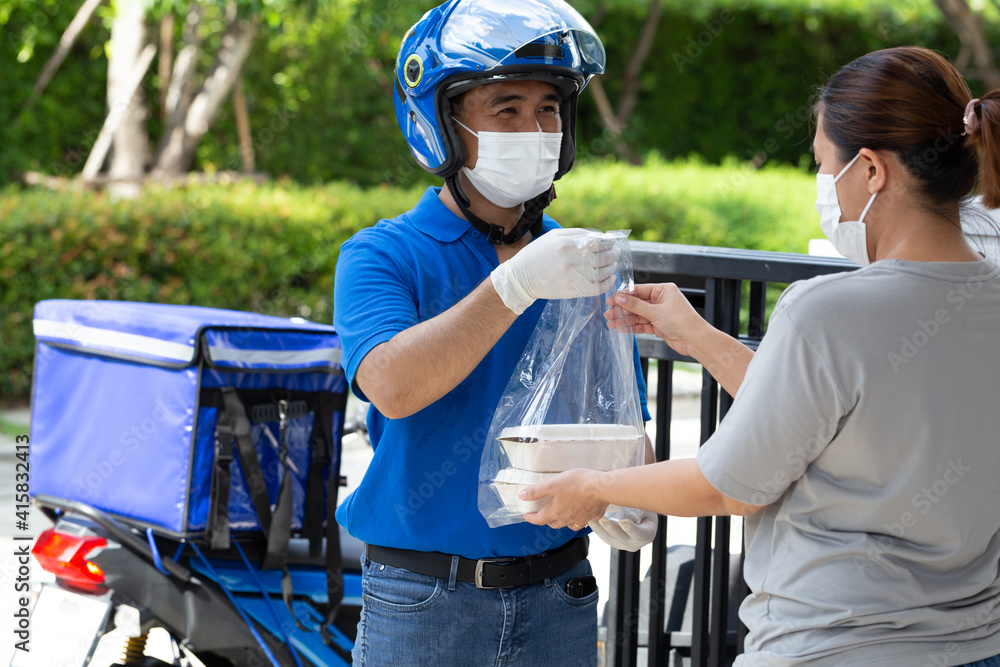 Asian deliverman wearing face mask holding plastic bag with food box delivery to woman customer, Motorbike delivering food or parcel express service Asian deliverman wearing face mask holding plastic bag with food box delivery to woman customer, Motorbike delivering food or parcel express service
