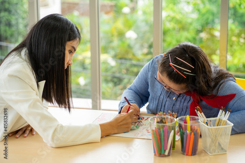 Asian Autism girl playing and learning in special school with young teacher