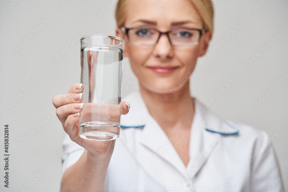Healthy eating or lifestyle concept - female woman doctor holding and a glass of clear fresh water Healthy eating or lifestyle concept - female woman doctor holding and a glass of clear fresh water