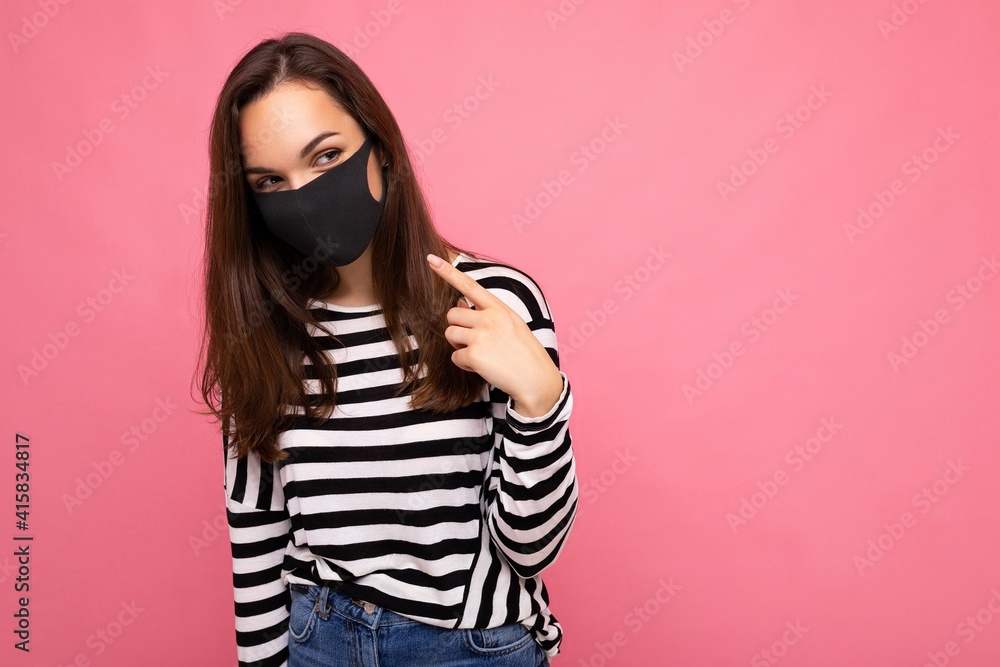 Shot of young attractive woman wearing mediacal face mask isolated over background wall. Protection against COVID-19 Shot of young attractive woman wearing mediacal face mask isolated over background wall. Protection against COVID-19