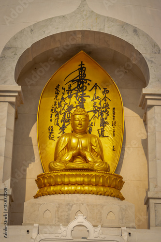 Budhha praying golden statue isolated in details from unique perspective