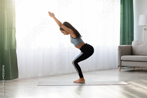 Caucasian millennial woman doing morning yoga at home