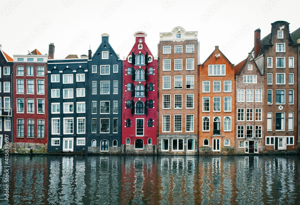 Colorful houses lining Damrak canal in Amsterdam, Netherlands