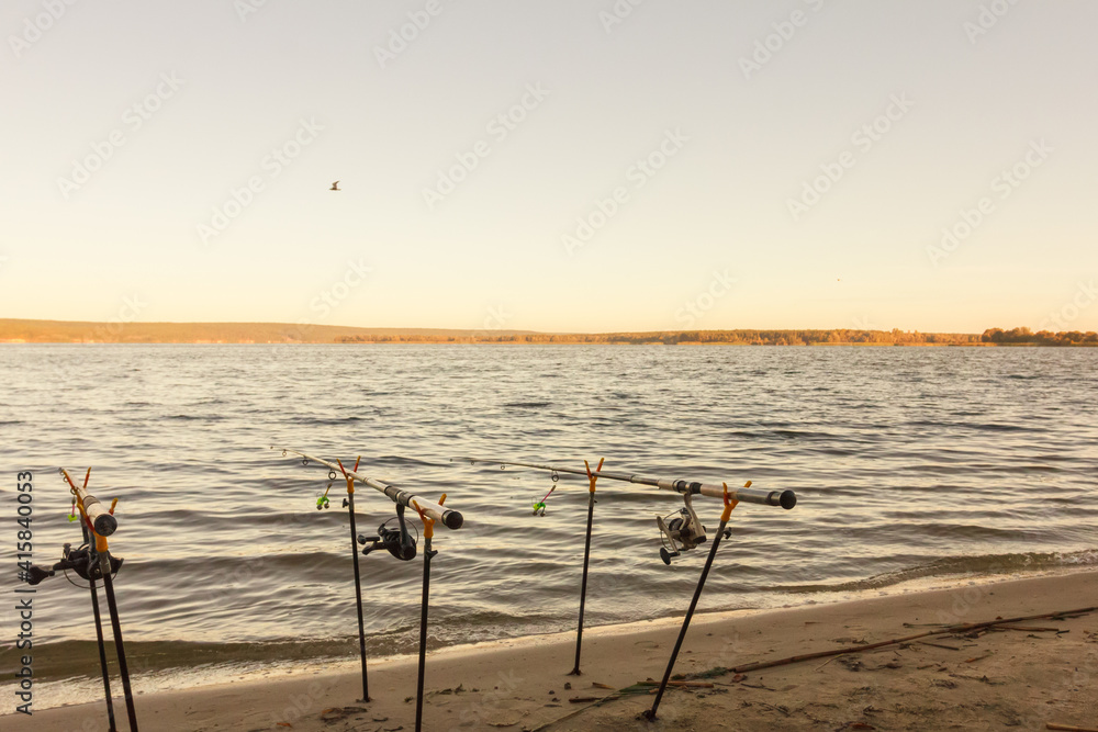 Fishing rods and fishing gear on the river bank, lake coast. Fishing rods and fishing gear on the river bank, lake coast.