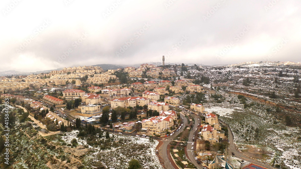 Jerusalem red rooftops in the snow aerial view
,drone view over mevasert zion close to Jerusalem covered with snow, February 2021
