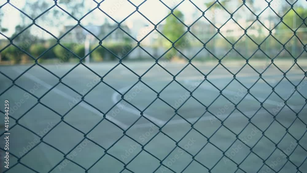 Empty playground fenced with metal wire fence during sports ban due to coronavirus pandemic Empty playground fenced with metal wire fence during sports ban due to coronavirus pandemic