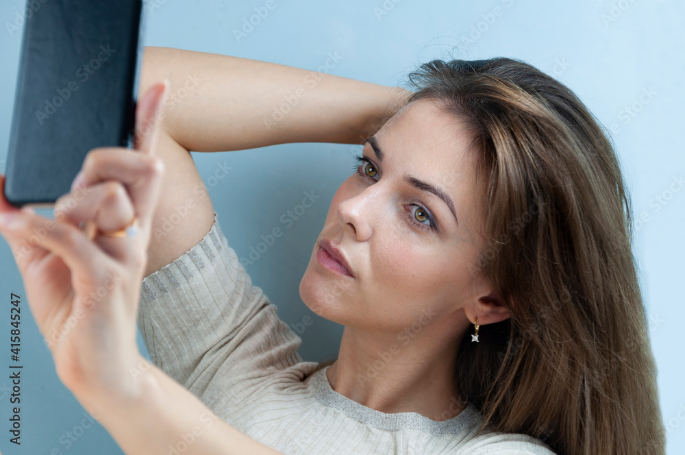 Fototapeta premium Woman selfie photo with smartphone on a blue background