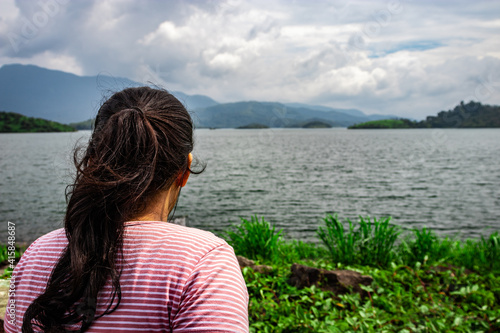 girl looking at pristine lake with mountain background