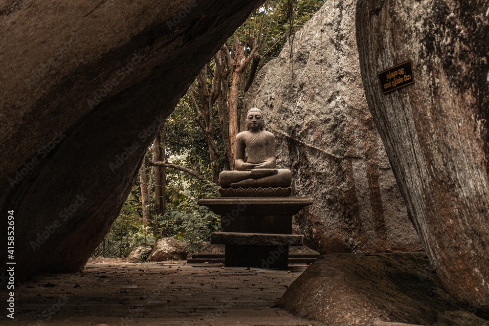 Obraz premium Posąg Buddy na kamiennym tle.