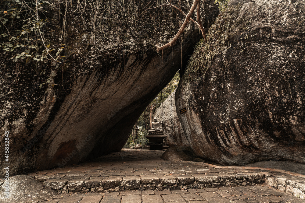 Obraz premium Posąg Buddy na kamiennym tle.