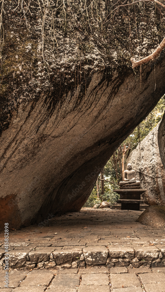 Obraz premium Posąg Buddy na kamiennym tle.