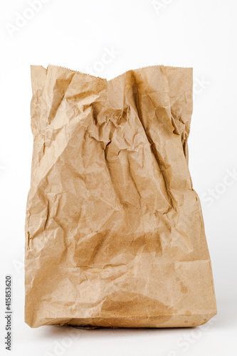 Crumpled paper bag with greasy spots on a white isolated background. Recycling of secondary waste