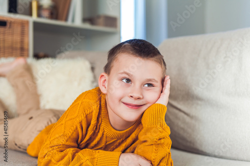 Happy boy 6 years old is resting on the sofa.