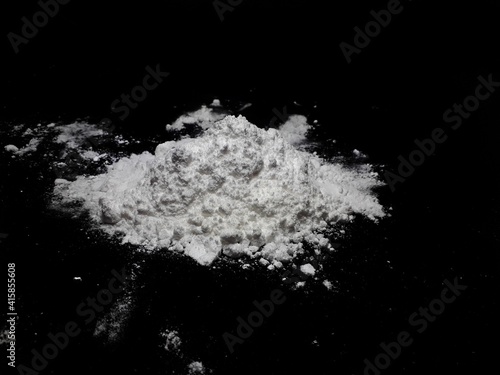 Cocaine drug powder pile on black background