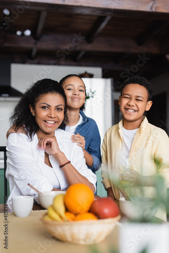 happy african american family near fruits on blurred foreground
