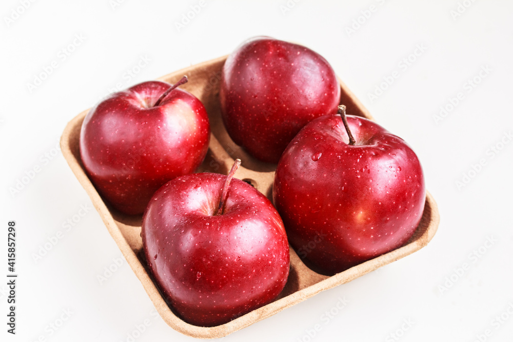 Tasty red apples on biodegradable pulp paper food tray isolated on white. Recyclable packaging concept. Top view, flat lay, copy space Tasty red apples on biodegradable pulp paper food tray isolated on white. Recyclable packaging concept. Top view, flat lay, copy space