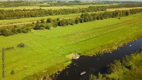 Aerial view of the Weerribben National Park, Overijssel, The Netherlands.
Dolly shot from canal with boat towards wetlands and woodland. photo