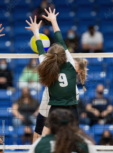 Canvas Print Young athletic girl competing in a volleyball game