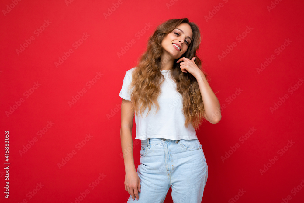 Portrait of young beautiful smiling hipster woman in trendy outfit. Sexy carefree female person posing isolated near red wall in studio with free space. Positive model with natural makeup Portrait of young beautiful smiling hipster woman in trendy outfit. Sexy carefree female person posing isolated near red wall in studio with free space. Positive model with natural makeup