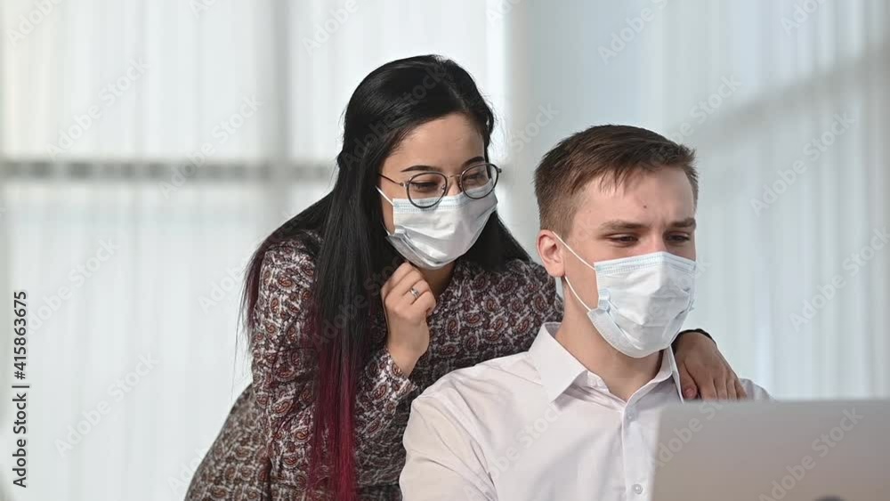 Multinational family in protective medical masks in bright living room communicate via video link with friends. man and woman say that are sick and cough in camera. Social distance for health care Multinational family in protective medical masks in bright living room communicate via video link with friends. man and woman say that are sick and cough in camera. Social distance for health care