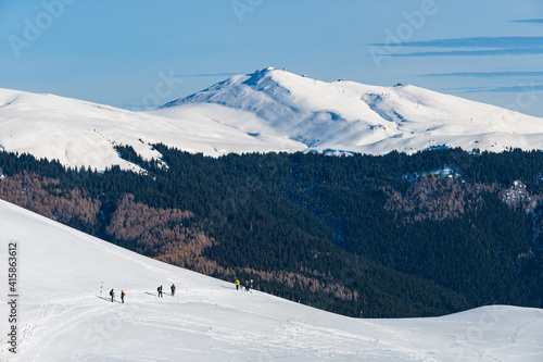 Obraz na płótnie Group of young people hiking in snowy Romanian mountains during a sunny winter day w salonie