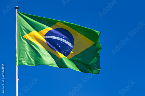 Obraz na plátně Brazilian flag waving atop of its pole