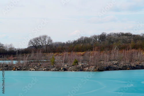 Blaue Lagune in Beckum, Nordrhein Westfalen. Gefrorener See, fotografiert im Winter bei sonnigem Wetter.