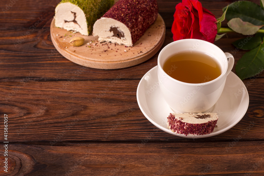Cup with tea t oriental sweet chocolate halva with pistachios and pink powder Cup with tea t oriental sweet chocolate halva with pistachios and pink powder